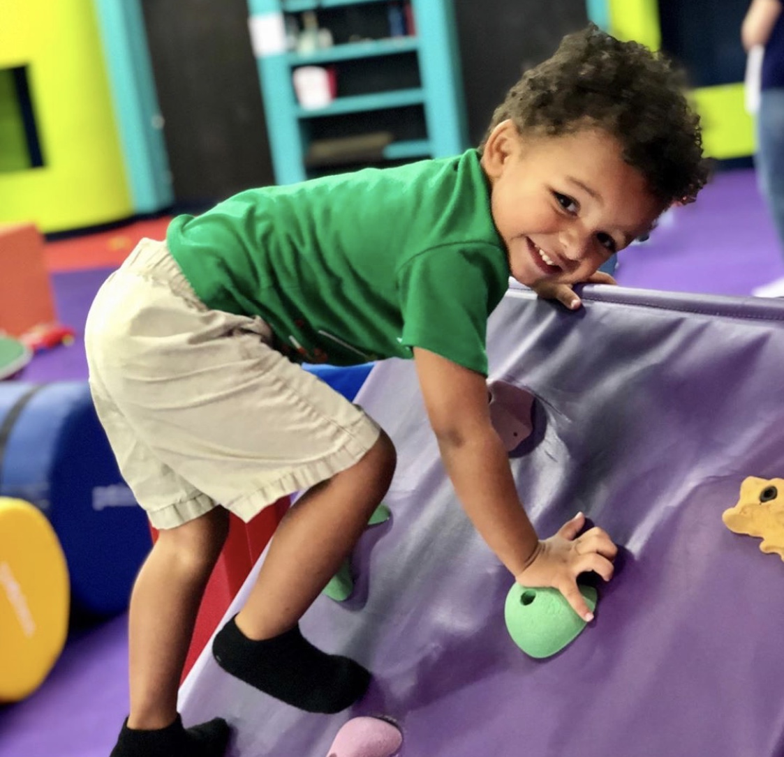 A little girl playing on Romp n' Roll's gym equipment, contact us today for our parents morning out event in Katy, TX. 