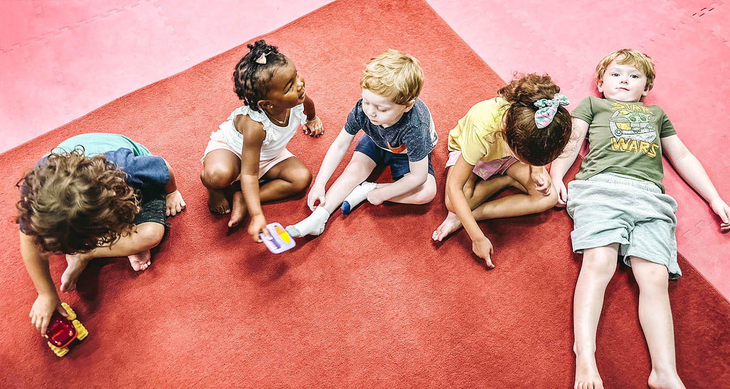 
				Kids sitting on the floor at Romp n' Roll - the perfect toddler classes in Wellesley, VA.
			