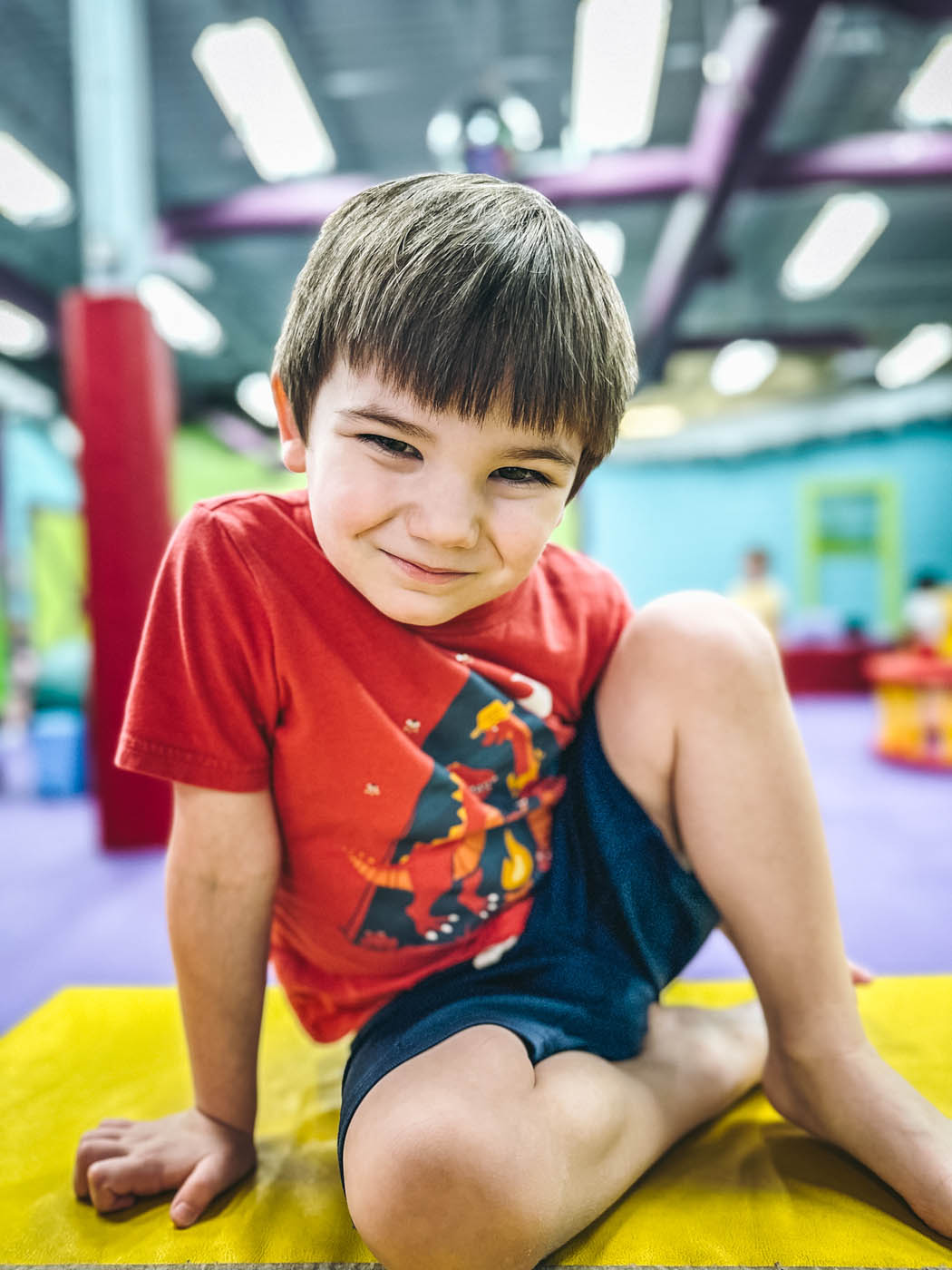 An older kid sitting on the floor at Romp n' Roll.