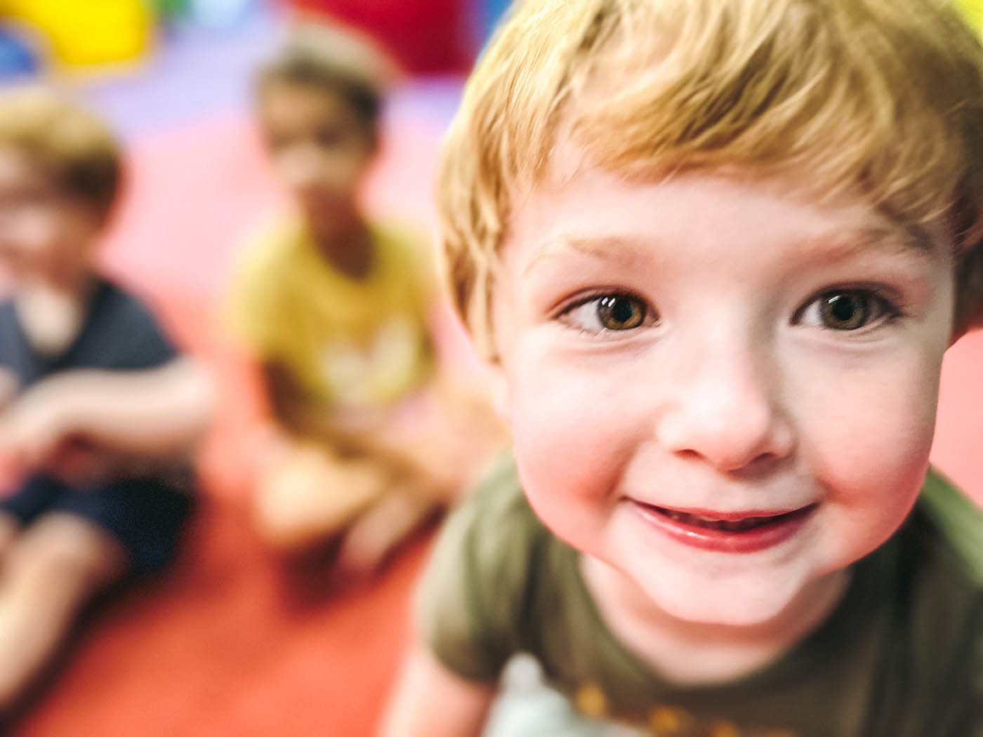 A baby boy smiling while playing at Romp n' Roll, contact us for things to do in Midlothian, VA.