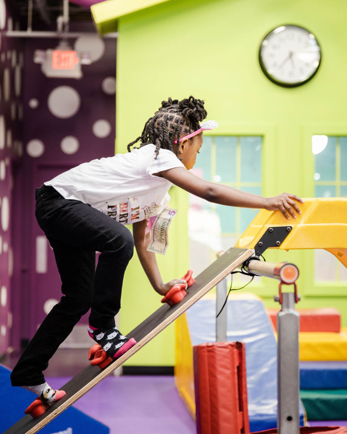 An older girl climbing on gym equipment at Romp n' Roll in Glen Allen, VA.