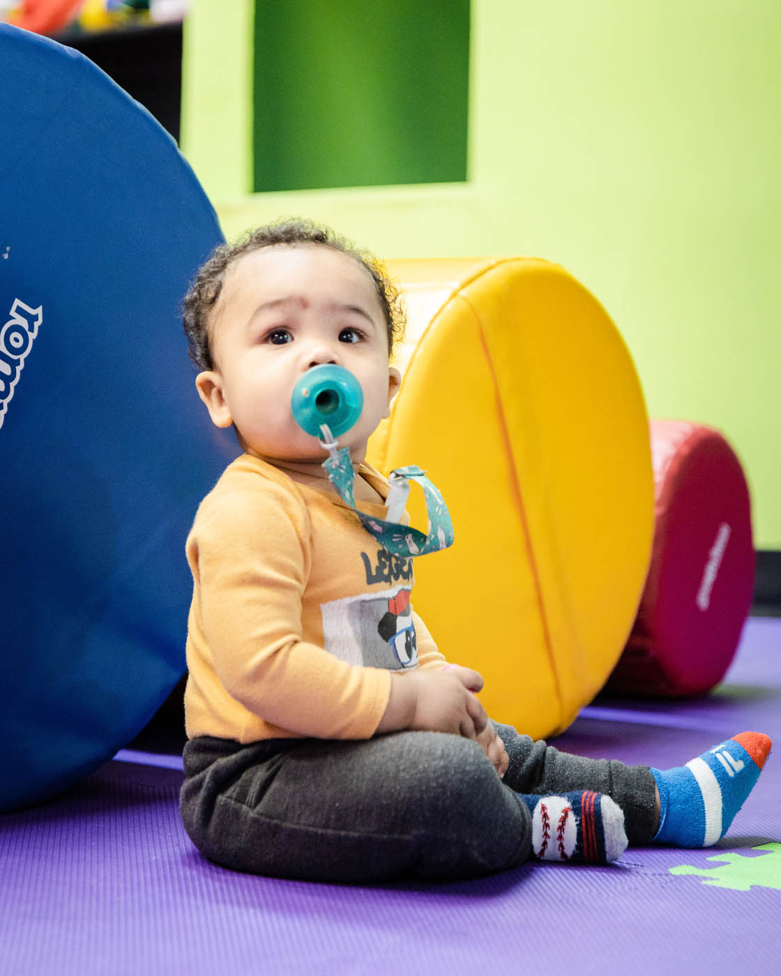 A baby playing with blow up balls, pick Romp n' Roll Katy today for your kids play area in Katy, TX.