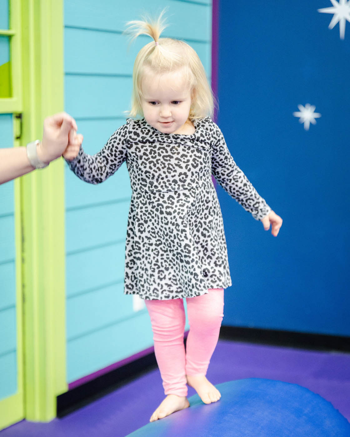 Romp n' Roll little girl playing on gym euqipment at our winter camps for in Midlothian, VA. 