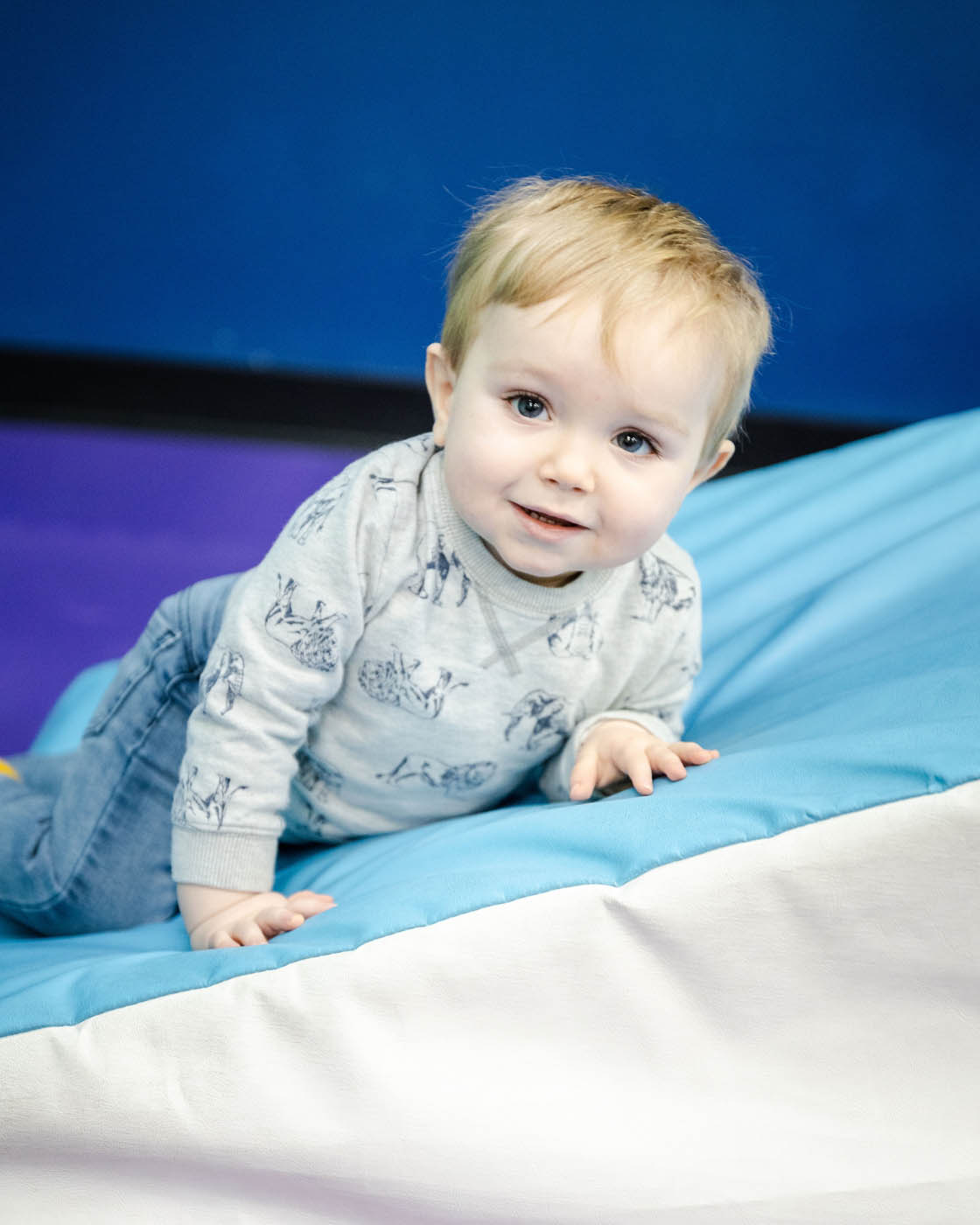 A baby boy taking advandage of Romp n' Roll Katy's baby gym.