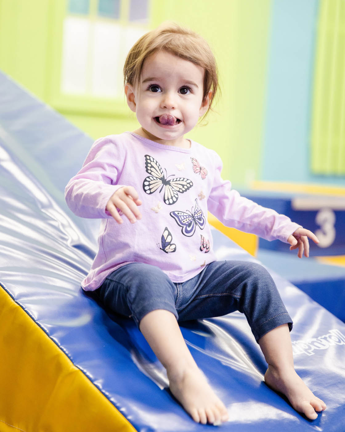 A little girl on padded gym equipment at Romp n' Roll.