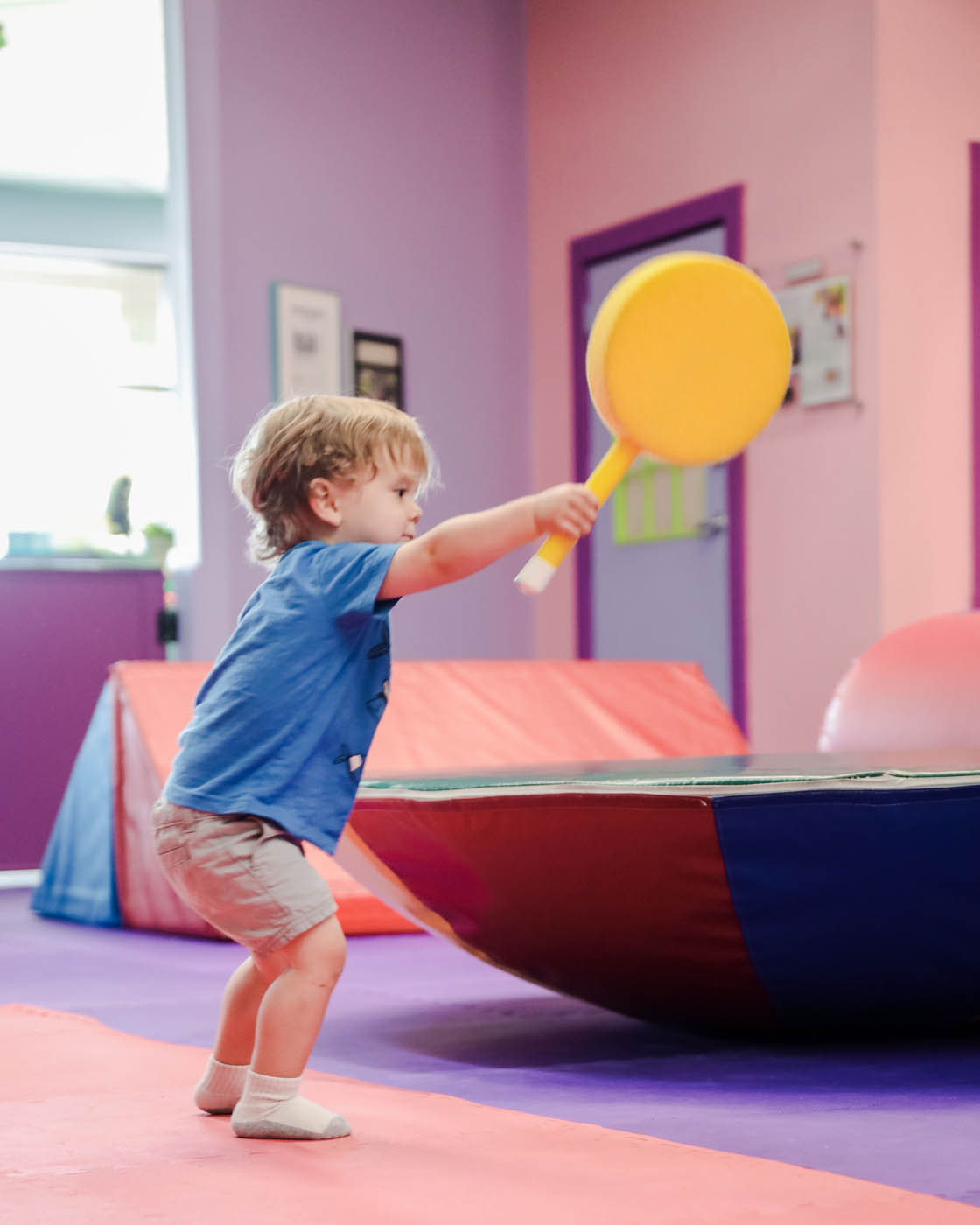 Romp n' Roll little boy playing racket tennis, contact us today about our affordable summer camps in Katy, TX. 