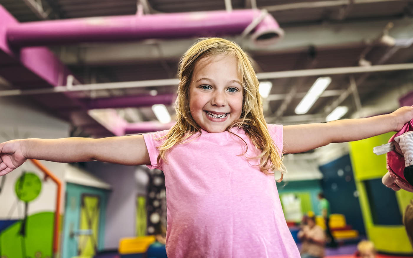 An about 5 year old girl playing in Romp n' Roll West End's gym.