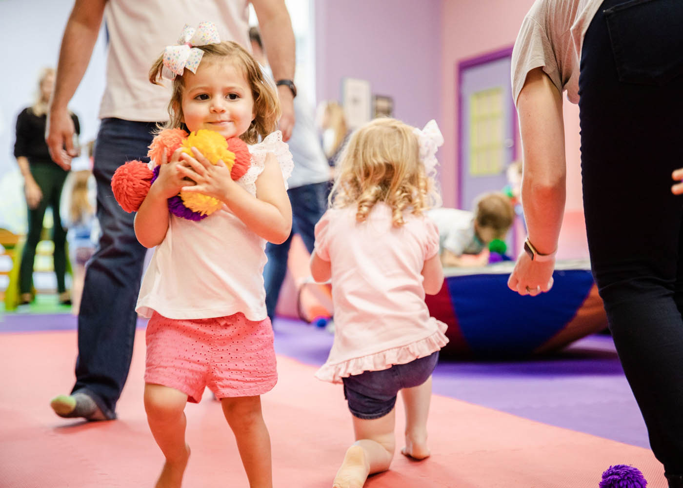 Two kids gathering fluffy balls and enjoying their time in sports for 3 year olds classes in Charlotte, NC.