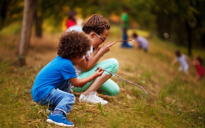 Kids playing outside and learning new ideas from Romp n' Roll.