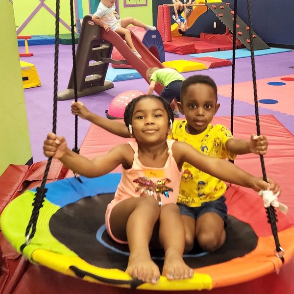 A cute girl smiling at a Romp n' Roll preschool plus program activity!