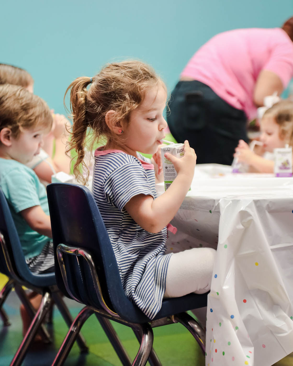 A littel girl sipping from a juice box at Romp n' Roll's birthday party in Katy, TX.