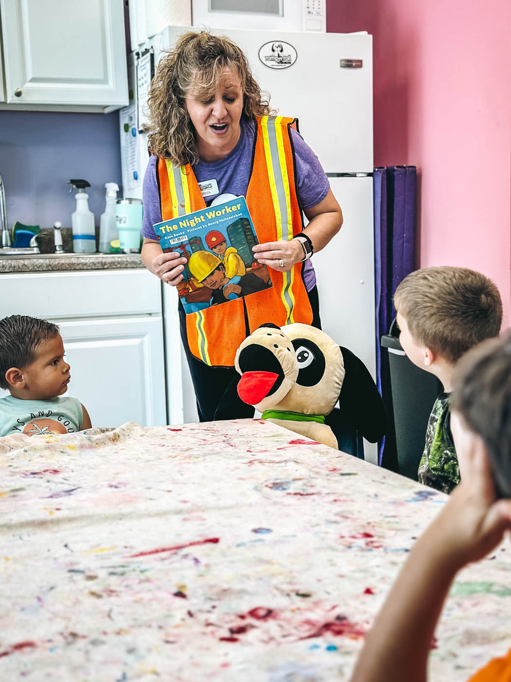 A Romp n' Roll instructor holding a book - join one of our stem classes for kids today. 