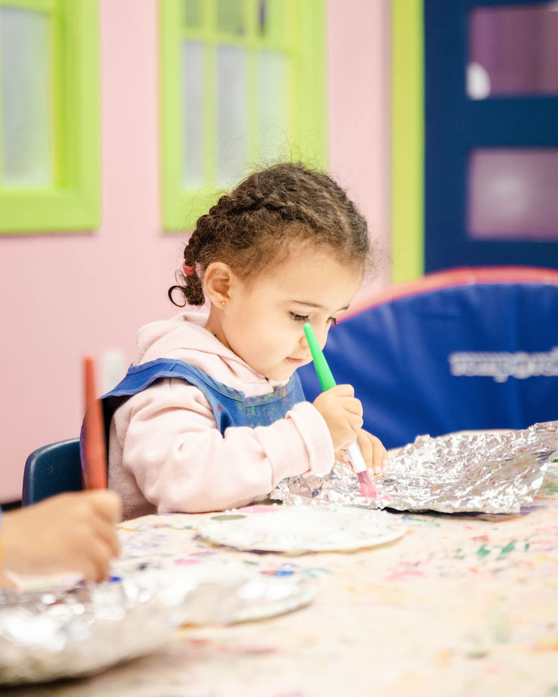 A little girl drawing at one of Romp n' Roll fall break camps in Glen Allen, VA.