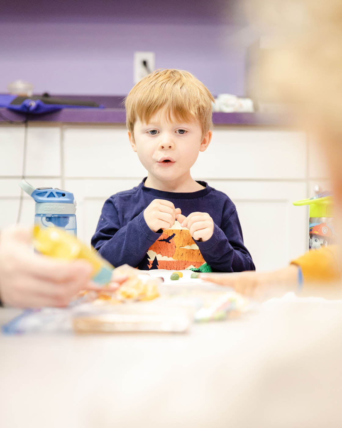 A child at Romp n' Roll enjoying the taste of food during Glen Allen cooking classes for kids.