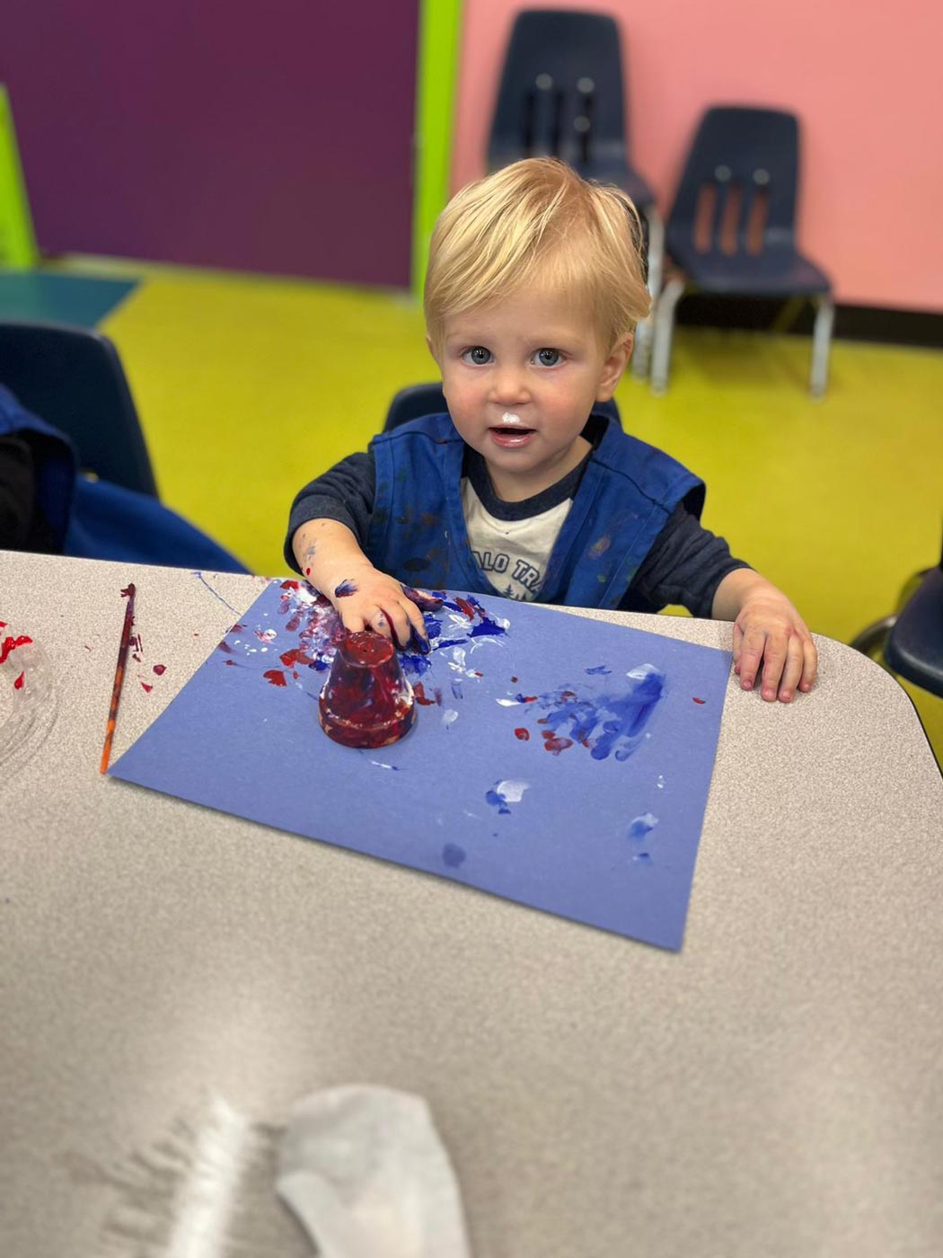 A little boy painting at at Romp n' Roll Katy's spring camps for kids.