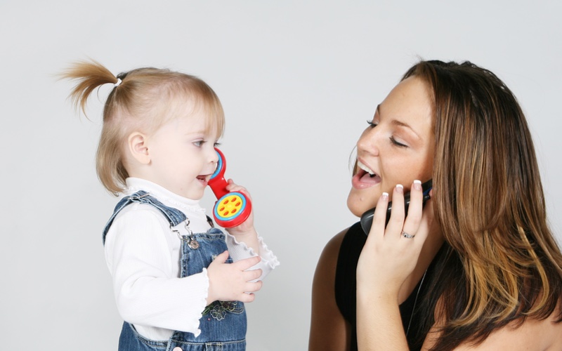 Mom communicating with her toddler on the phone, playing and asking questions learned at Romp n' Roll.